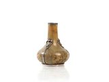 un petit vase en verre muni d'une anse, posé sur une surface blanche