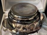 a silver plate in a box on a white cloth