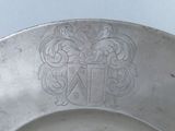 a silver plate with a coat of arms on it