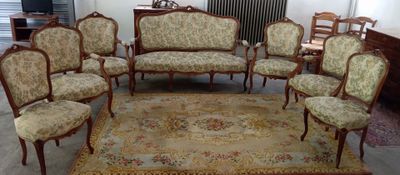 plusieurs chaises et un tapis dans une pièce