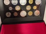 a black case with coins inside of it sitting on a red cloth