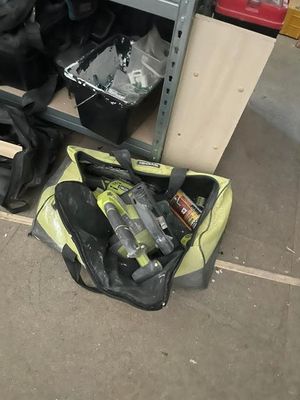 a bag of tools sitting on the floor next to a workbench