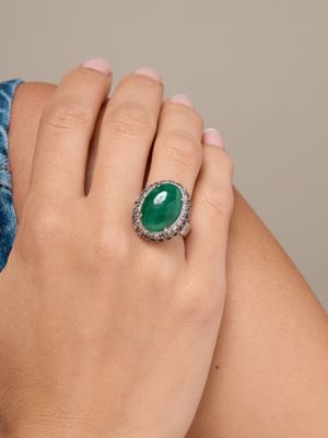La femme porte une bague sertie d'une pierre verte.
