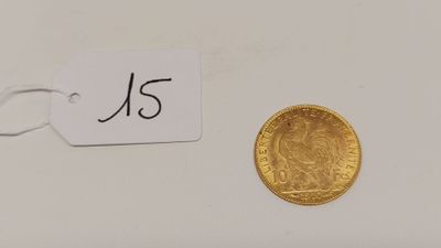 un gros plan d'une pièce d'or sur laquelle est accrochée une étiquette
