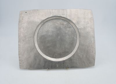 a silver plate with a circular design on it