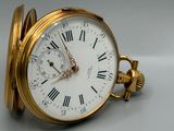 une montre de poche en or avec des chiffres romains sur le cadran