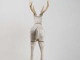 a wooden sculpture of a deer with antlers on it ' s back