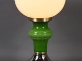 a green table lamp with a white glass shade on top