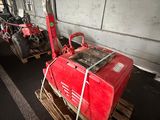 a red machine that is sitting on top of a pallet
