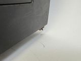 a bug crawling on the side of a black cabinet