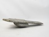 concrete sculpture of a bird on top of a rock on a white surface