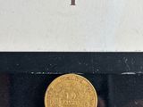 a close up of a gold coin on display in a glass case