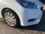 the front end of a white car parked in a parking lot