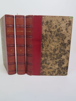 trois livres rouges superposés sur une surface blanche