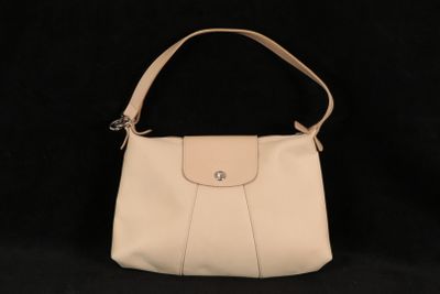 un sac à main blanc posé sur une surface noire