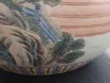 a vase with a painting on it sitting on a table