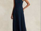 une femme en robe bleue, debout devant un fond blanc
