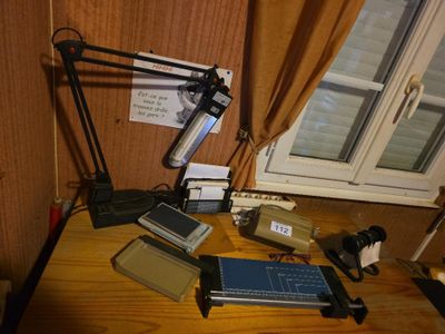 un bureau sur lequel se trouvent un ordinateur portable, un appareil photo, un téléphone portable et d'autres appareils électroniques