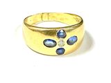 une image montrant un gros plan d'une bague en or sertie de pierres bleues