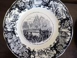 a black and white plate with a picture of a horse drawn carriage