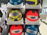 Des cartons de ballons de football sont empilés sur une table dans un magasin.