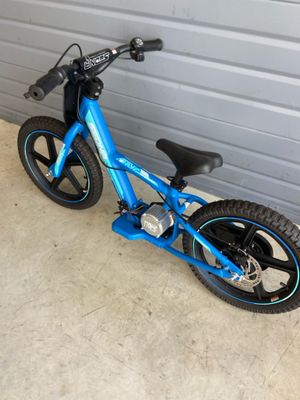 un vélo bleu garé devant la porte d'un garage