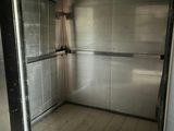 a small room with a metal door and a tiled floor