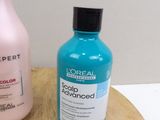 a bottle of sham and a bottle of conditioner sitting on a cutting board