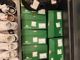 many pairs of shoes on a shelf in a shoe store