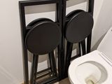 a toilet with two stools next to it in a bathroom