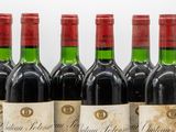 six bottles of red wine are lined up on a table