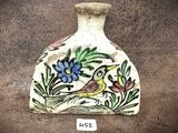 un petit vase sur lequel sont peints un oiseau et des fleurs
