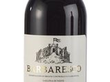 the bottle of wine is sitting on a white surface