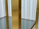 a close up of a glass shelf with a gold metal frame