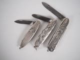 several knives are lined up on a white surface with one knife in the middle