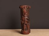 un gros plan d'une statue en bois posée sur une table, sur fond noir