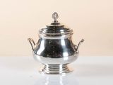 silver plated teapot with lid on stand on white surface