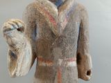 statue of a man holding a shoe and a bag