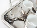 a silver tray with coffee cups and spoons on it