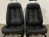 a pair of black leather seats on a pallet in a warehouse