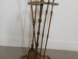 four brooms on a stand in the middle of a room