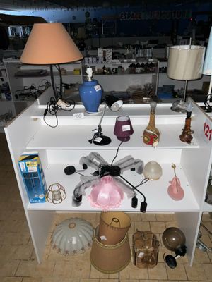 une étagère blanche sur laquelle sont posés de nombreux objets, dans une pièce