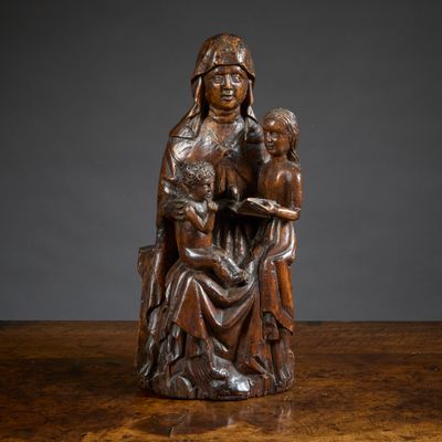 a wooden statue of a woman holding a child on a table