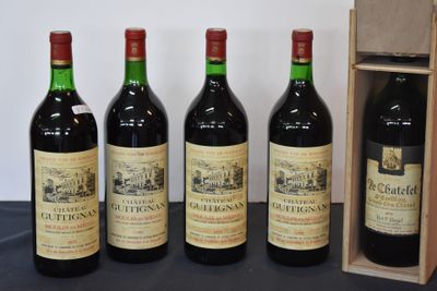 quatre bouteilles de vin sont alignées les unes à côté des autres près d'une caisse en bois