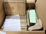 a cardboard box filled with lots of books and papers