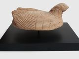 sculpture of a bird on a black stand on a white background