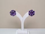 pair of purple crystal earrings on a white stand on a table