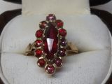 une bague sertie d'une pierre rouge, exposée sur un présentoir