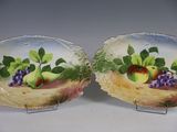 deux assiettes sur lesquelles sont peints des fruits, posées sur une table