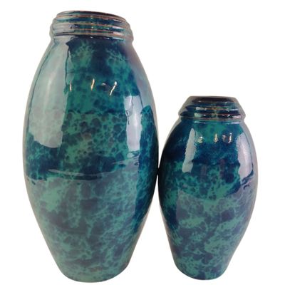 deux vases bleus posés l'un à côté de l'autre sur une surface blanche